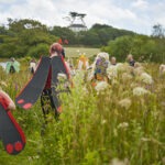 Families performing in a wet meadow because they have dressed up as Burnet Moths.